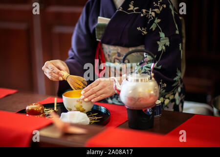 Una donna che indossa un kimono durante una tradizionale cerimonia del tè giapponese Foto Stock