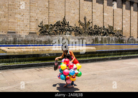 Venditore di palloncini presso la City fondando scultura sulla parete posteriore del Teatro Degollado, Centro storico, Guadalajara, Jalisco, Messico. Foto Stock