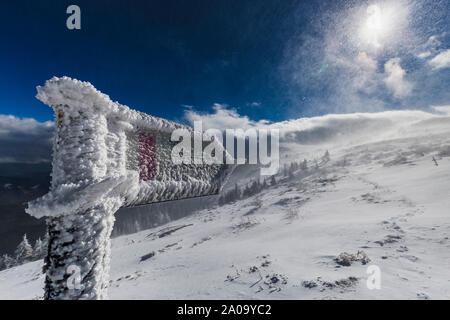 Cartello turistico congelati in Blizzard, giornata di sole Foto Stock