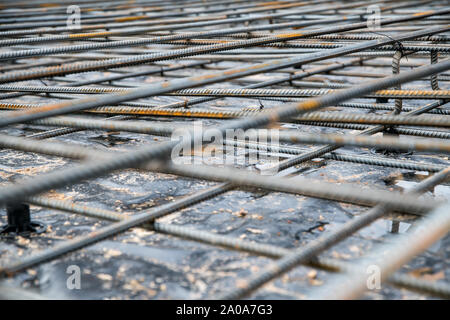 Anima di rinforzo di acciaio e barre di barre per la colata di cemento in un cantiere con una profondità di campo ridotta Foto Stock