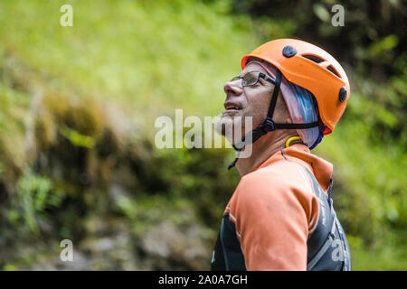 Ritratto di un uomo che indossa il casco di arrampicata e muta. Foto Stock