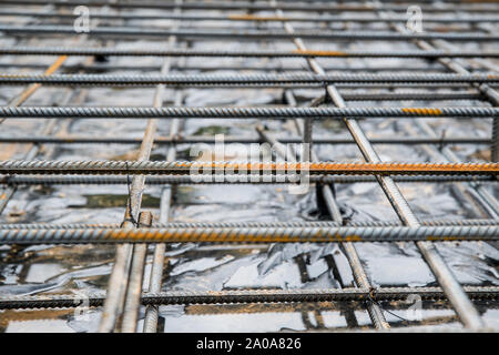 Anima di rinforzo di acciaio e barre di barre per la colata di cemento in un cantiere con una profondità di campo ridotta Foto Stock