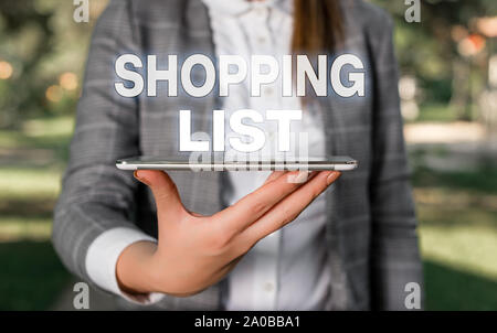 Parola di scrittura di testo la lista della spesa. Business photo vetrina approccio disciplina per lo shopping gli elementi di base per acquistare la scena esterna con business donna detiene Foto Stock