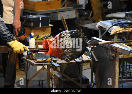 Soffiatore di vetro formando, girando vetro riscaldato in una bellissima, decorativo vaso di vetro in una manifattura nell' isola di Murano, Venezia, Italia Foto Stock