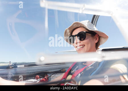 Donna sorridente dentro il parapendio cockpit Foto Stock