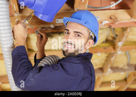 Cacciavite builder riparando le griglie di ventilazione Foto Stock