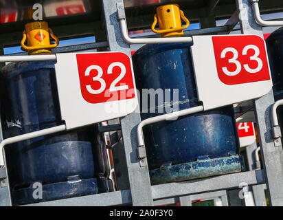 Primo piano di pacchi di bombole del gas su un distributore Foto Stock