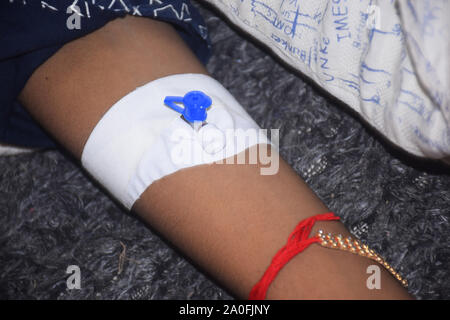 Un bambino indiano la mano che la febbre dei pazienti in ospedale per dare incoraggiamento Foto Stock