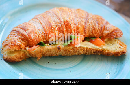 Foto macro di un delizioso cornetto con erbe aromatiche e salmone panna acida in un ristorante Foto Stock