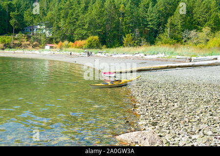 Un kayak giallo sulla spiaggia di Medicine Beach a North Pender Island, British Columbia, Canada Foto Stock