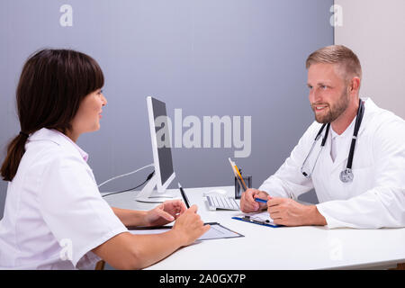 Close-up di un maschio di medico e infermiere a discutere insieme su esame medico all'ospedale Foto Stock