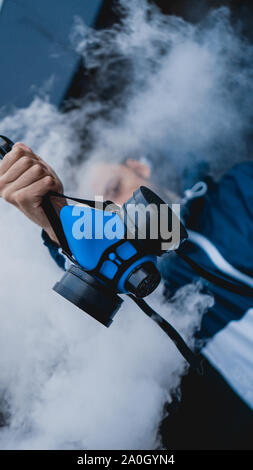 Respiratore di protezione semi maschera per gas tossici.L'uomo preparare alla protezione da usura dell'inquinamento atmosferico. Chi detiene un respiratore, il braccio esteso in avanti Foto Stock