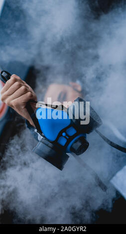 Respiratore di protezione semi maschera per gas tossici.L'uomo preparare alla protezione da usura dell'inquinamento atmosferico. Chi detiene un respiratore, il braccio esteso in avanti Foto Stock