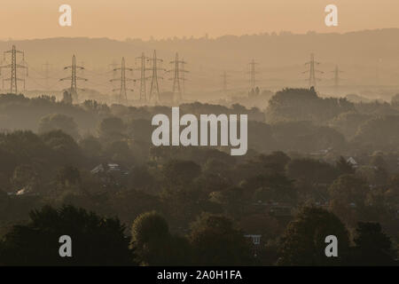 London, Regno Unito - 20 Settembre 2019: Elettricità tralicci che si elevano al di sopra di un paesaggio nebbioso a Wimbledon durante il sunrise .Credito: amer ghazzal/Alamy Live News Foto Stock