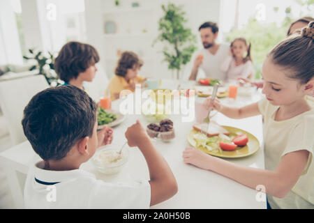 Nizza adorabili bella bella famiglia adottiva, mulato, avente la cena e il pranzo di mangiare una gustosa insalata vegetariana, vegs, godendo le vacanze, luce bianca inter Foto Stock