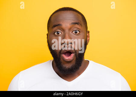 Close-up ritratto di bello attraente manly scioccato mulato ragazzo in t-shirt bianco, aperto bocca, isolate su bright vivid sfondo giallo Foto Stock