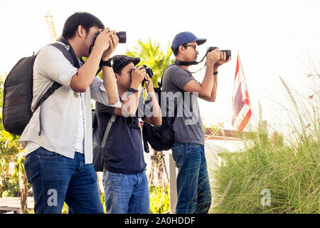 I turisti maschi di scattare foto con una fotocamera mentre si è in viaggio. Le gite sono paesaggi fotografati in Thailandia. Un gruppo di uomini sono in piedi la fotografia sul th Foto Stock