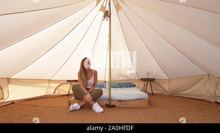 Giovane donna all interno di una tenda da campeggio Foto Stock