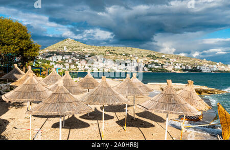 Ombrelloni di paglia su una spiaggia di Saranda, Albania Foto Stock