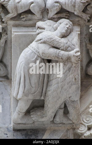 Immaginario medievale: un orso che abbraccia un uomo (XIII C) - facciata romanica del Duomo di San Martino a Lucca (Toscana, Italia) Foto Stock