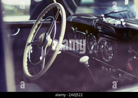 Close-up di un cockpit di un'auto d'epoca che mostra il volante e ingranaggio Foto Stock