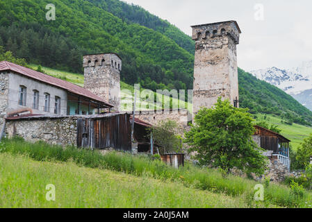 Pietra medievali torri difensive di Mestia, Svaneti, Georgia con case di abitazione intorno e annessi. Una tradizionale casa Svan. Foto Stock