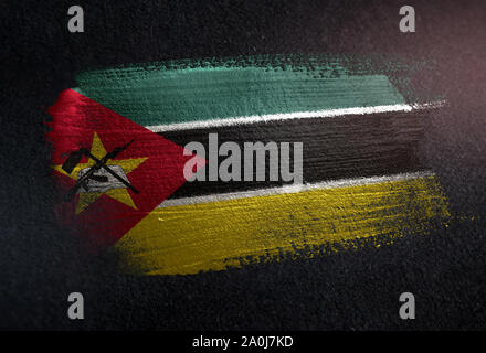 Mozambico bandiera fatta di spazzola metallica vernice su grunge parete scura Foto Stock