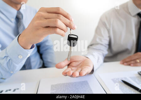 Business man agente di assicurazione offrono forma fissata al pad e penna in argento a firmare closeup. Certificato di assicurazione autoveicoli Politica e pianificazione con chiave auto Foto Stock