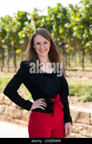 Palatinato, Germania. Xx Settembre, 2019. Meike Klohr, candidato per l elezione del tedesco della regina del Vino 2019 dalla regione del vino "Pfalz" sorride al fotografo la telecamera durante una sessione fotografica presso il Isler cantina. Credito: dpa picture alliance/Alamy Live News Foto Stock