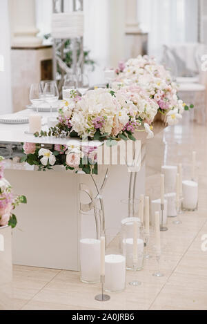 Lo sposo e la sposa 's splendida tavola di nozze è decorato con fiori e un sacco di diverse candele. Foto Stock