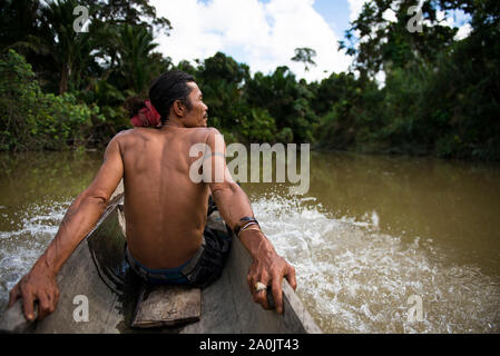 Mentawai Tribe Uomo seduto in canoa touring il fiume Foto Stock