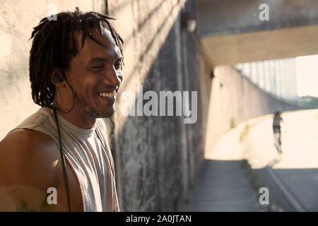 Uomo afro-americano di ridere che indossa gli auricolari Foto Stock