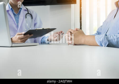 Ascolto paziente intensamente a un medico di sesso maschile che spiega i sintomi del paziente o porre una domanda come discutono di lavorare insieme in una consultazione Foto Stock