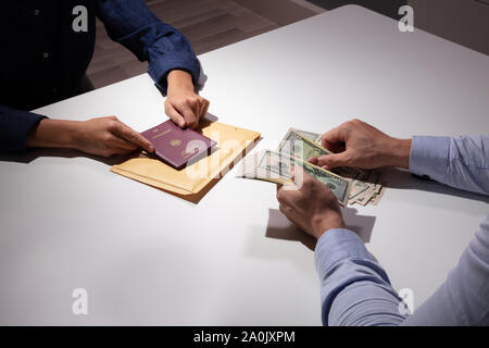 Close-up di un uomo di affari la valuta di conteggio per acquisto di falsi o falsificati Passaporto Foto Stock