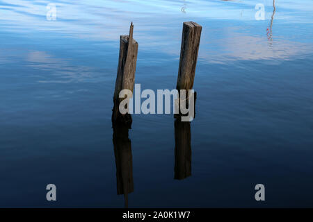 Vecchio pontile in legno pilastri sporgenti dal mare Foto Stock