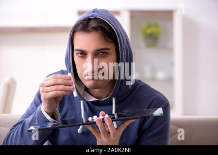 Il giovane uomo ha problemi con i narcotici a casa Foto Stock