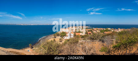 Gorea, Senegal - Febbraio 2, 2019: vista panoramica di case con il tetto rosso sull'isola di Goree con Dakar in background. Gorée. Dakar, Senegal. Foto Stock