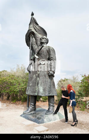 I capelli rossi donna di indossare tacchi alti e una tatooed l uomo nella sua 20's visite socialista figure dittatoriali e memoriali a statua Memento Park, Budapest Foto Stock