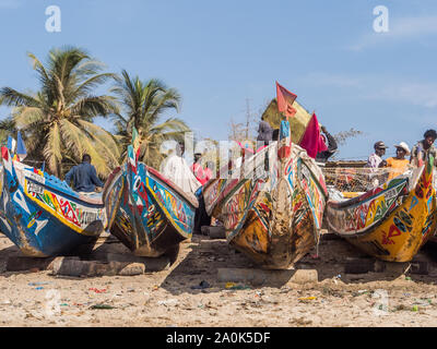 Nianing, Senegal - Gennaio 2, 2019: i pescatori la raccolta di pesce di legno colorato barca fisher permanente sulla spiaggia. Africa Foto Stock