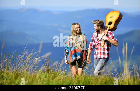 L'amore li ispira. Bella coppia romantica felice volti sorridenti sullo sfondo della natura. Ragazzo e ragazza con la chitarra. Escursionismo romance. Aria fresca e sentimenti puri. Passeggiata romantica. Canzone romantica. Foto Stock