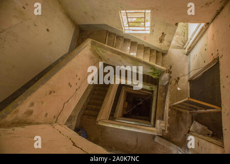 Interno del magazzino abbandonato e vista vertiginosa di scale Foto Stock