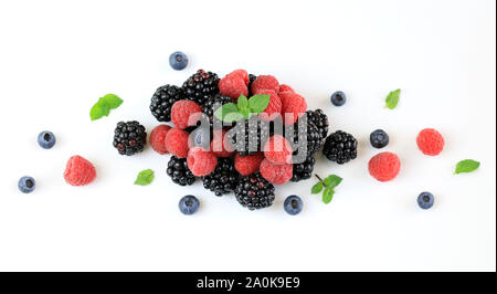 Frutti di bosco freschi. Lamponi, more e mirtilli con foglie di menta isolati su sfondo bianco. Vista superiore Foto Stock