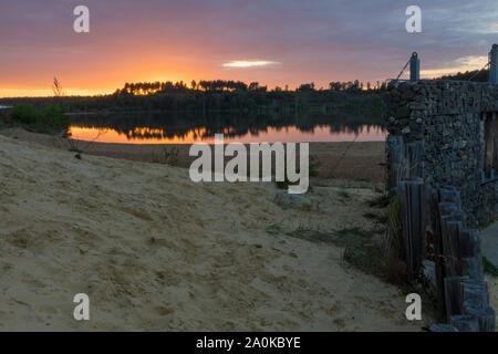 Tramonto al Mechelse Heide (Inglese prato Mechelse) con una vista panoramica di essere sulla spiaggia con sabbia e pali in legno Foto Stock