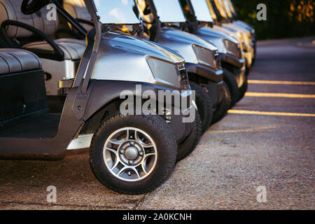 Golf carts schierate mattina presto presso il golf club pronto per tee time Foto Stock