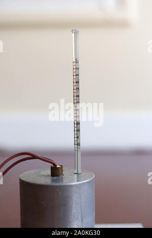 Capacità di calore specifico di esperimento di alluminio impostare senza isolamento. Il blocco di alluminio con un riscaldatore ad immersione e termometro su un tappetino resistente al calore Foto Stock