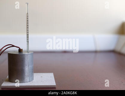 Capacità di calore specifico di esperimento di alluminio impostare senza isolamento. Il blocco di alluminio con un riscaldatore ad immersione e termometro su un tappetino resistente al calore Foto Stock