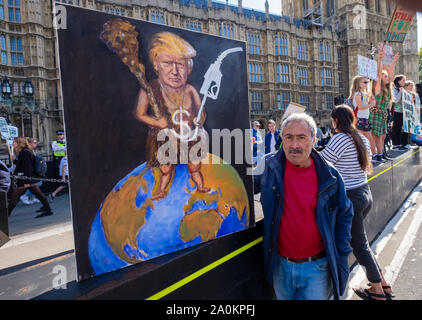 Londra, Regno Unito. Xx Settembre 2019. Artista politico Kaya Mar mantiene una sua fotografia che mostra Donald Trump con club e pompa di benzina in piedi sul globo in corrispondenza del clima globale sciopero a Londra. Peter Marshall / Alamy Live News Foto Stock