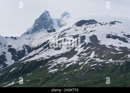 Montagna innevata massiccio con due picchi dietro che sono cime di montagna Ushba. Il trek da Mestia per Mazeri (Becho). La Georgia. Il Caucaso. Foto Stock