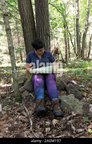 Con una cartina e bussola persona preapres per il loro viaggio nel bosco Foto Stock