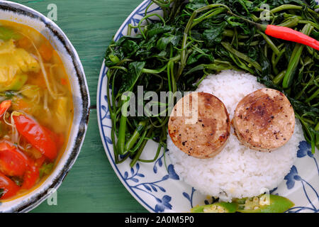 Piatto di riso, acqua bollita gloria mattutina, cuoco di salsiccia vegana con salsa, zuppa acida di pomodoro, okra, ananas, pasto vegetariano nutritivo Foto Stock